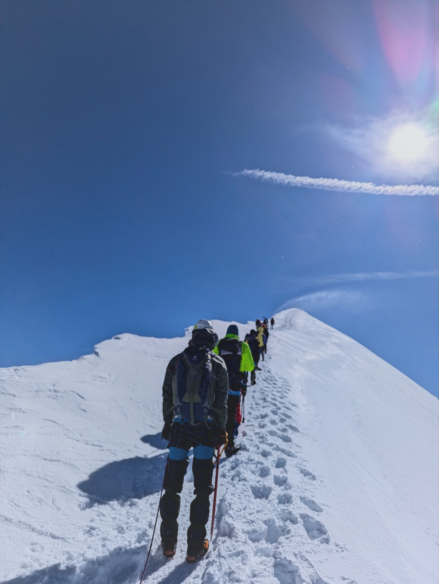 Climber on a snowy slope above the clouds